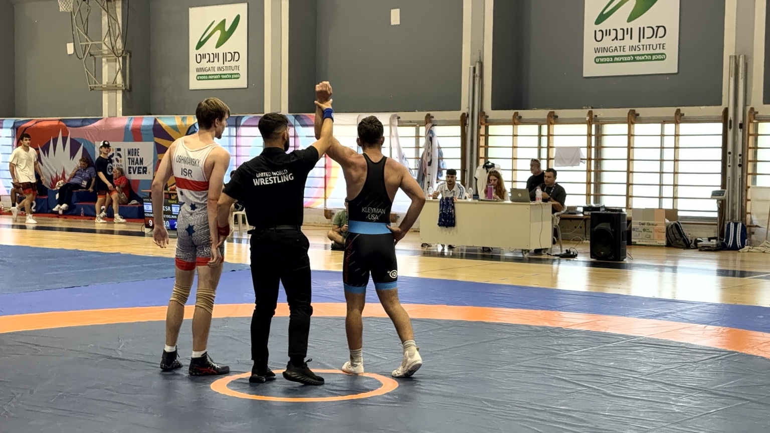 Marc Kleyman in a USA wrestling singlet with his arm raised after the match
